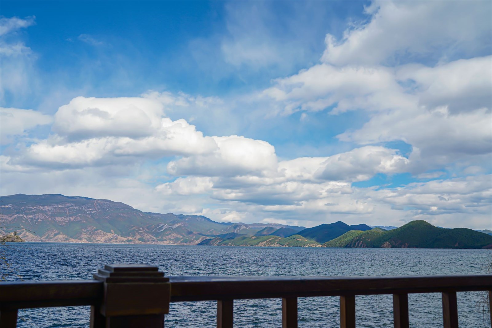 栏杆外辽阔的泸沽湖水面与对岸山峦